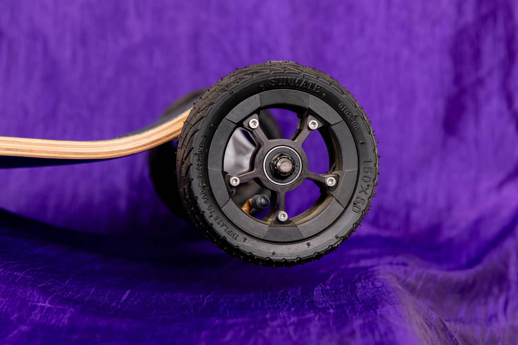 Skateboard wheel on purple background.