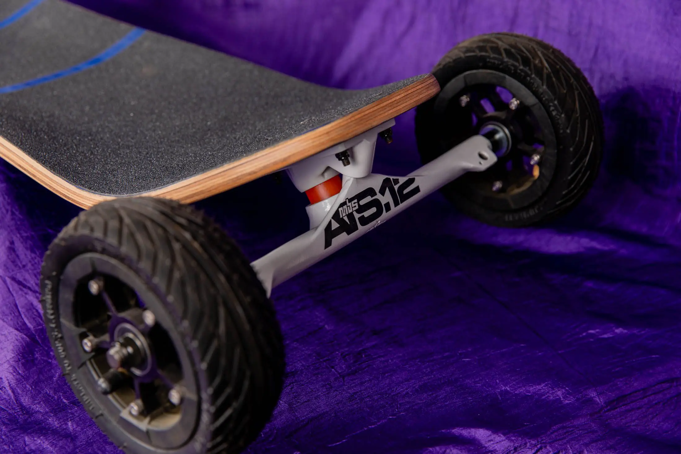 Off-road skateboard on purple fabric background.
