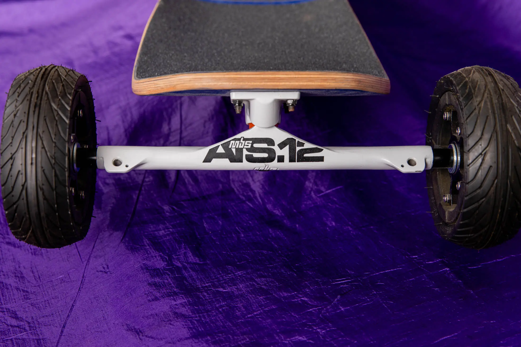 Skateboard with off-road wheels on purple background.