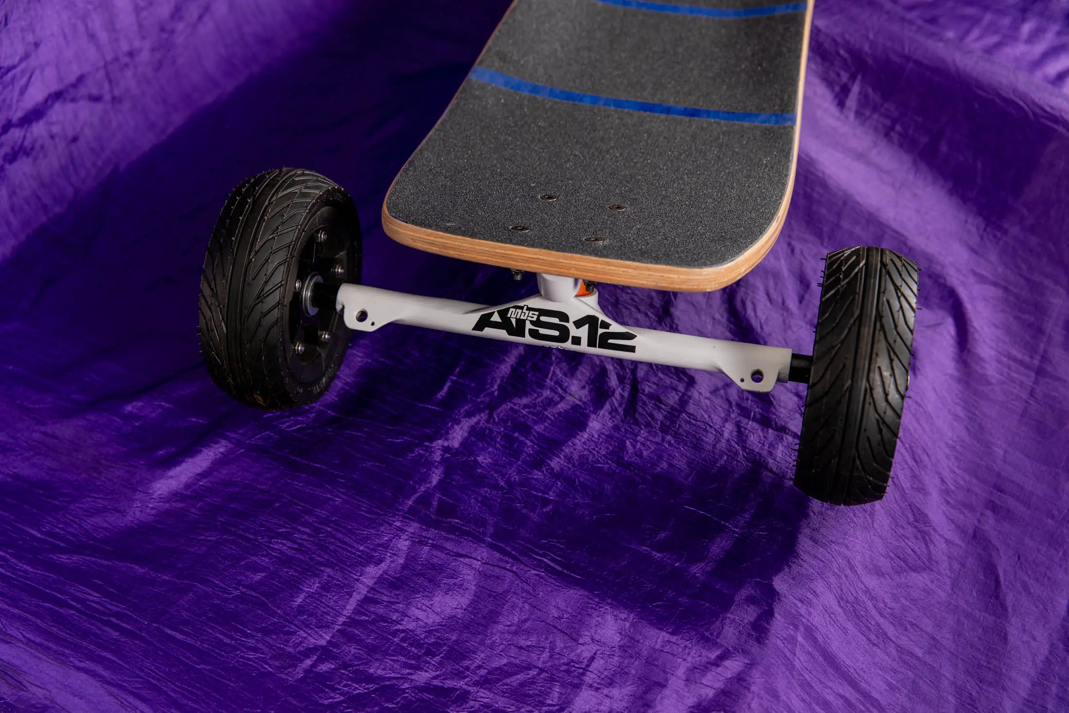 All-terrain skateboard on a purple background.