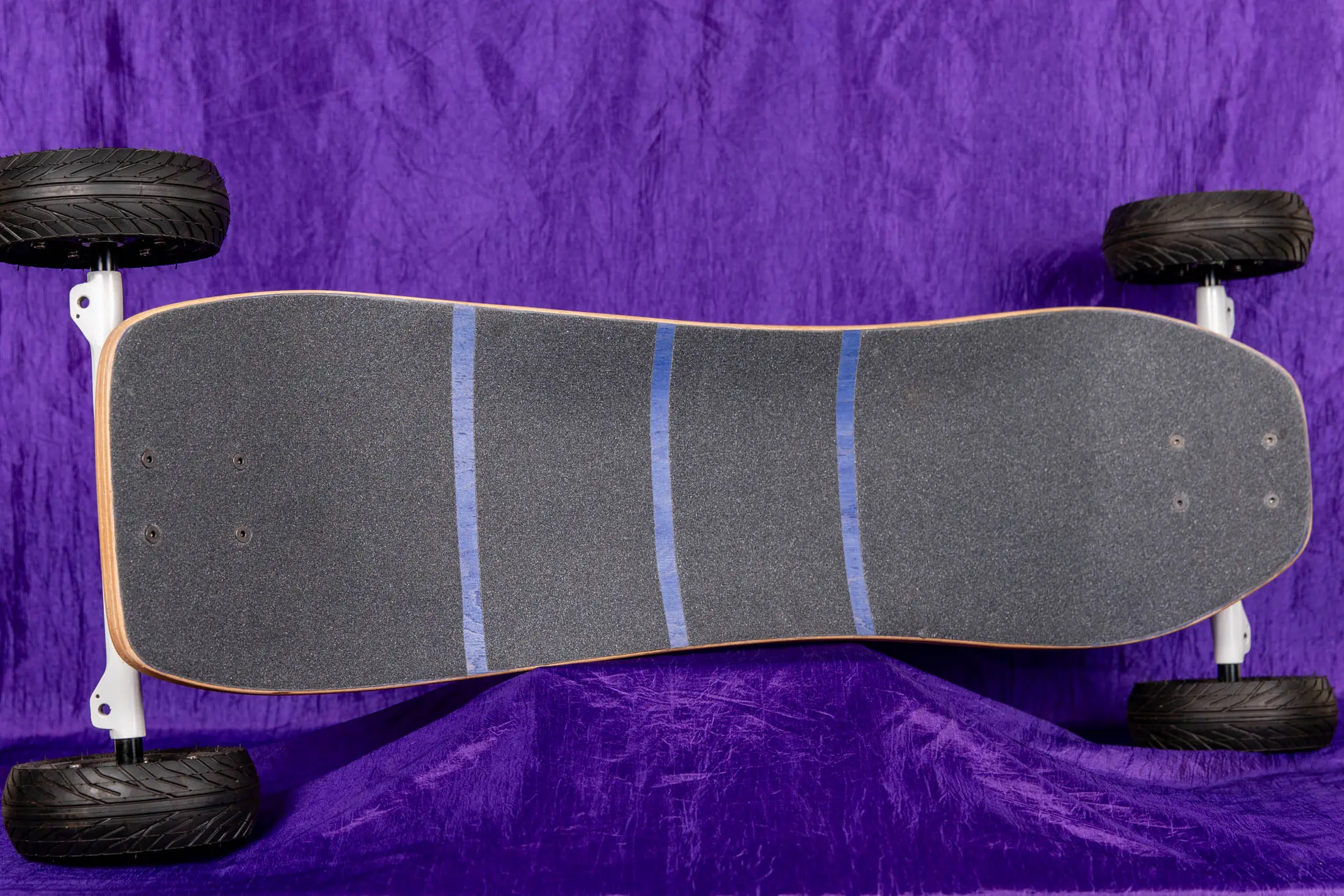 All-terrain skateboard on purple background.