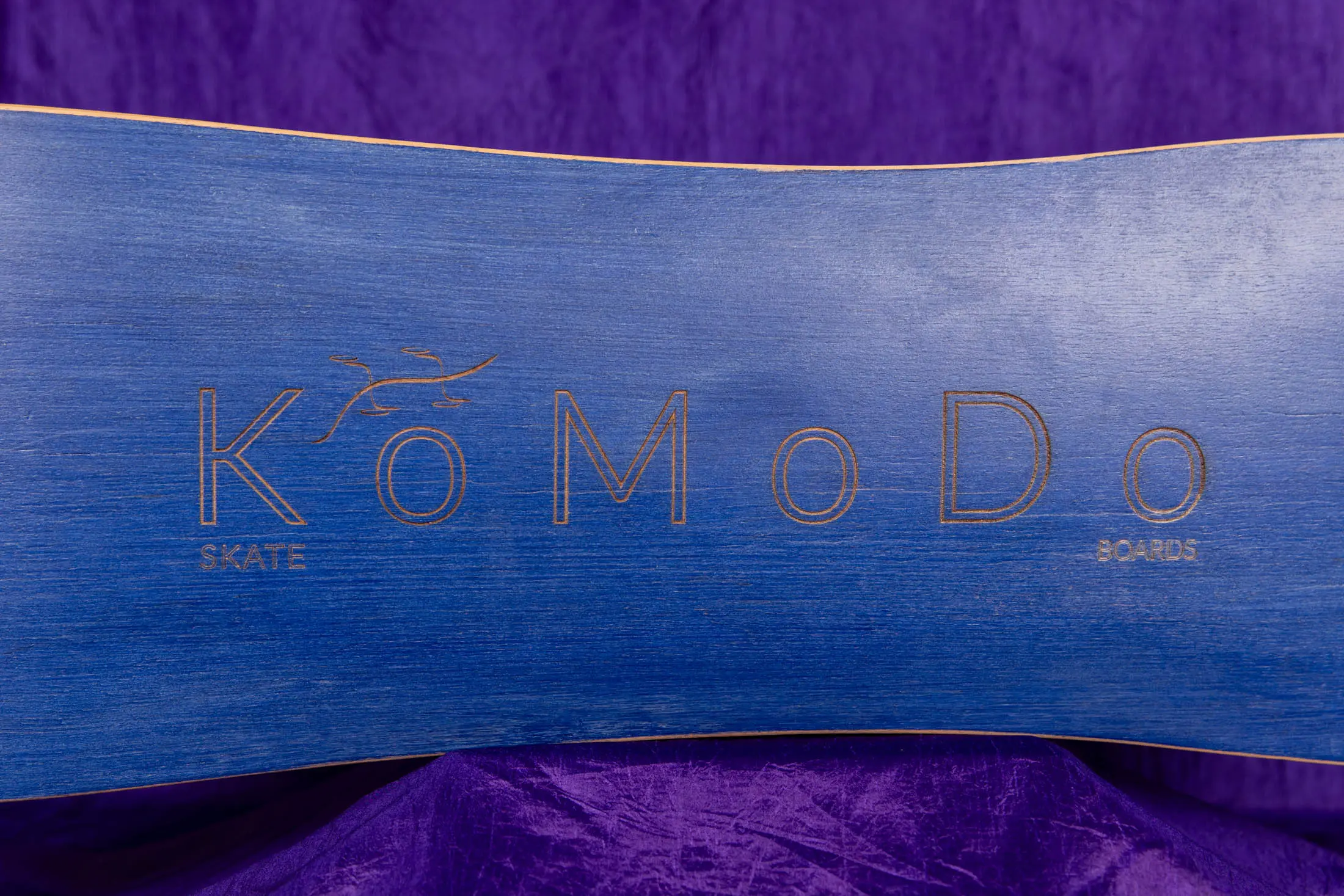 Blue skateboard with KoMoDo logo.