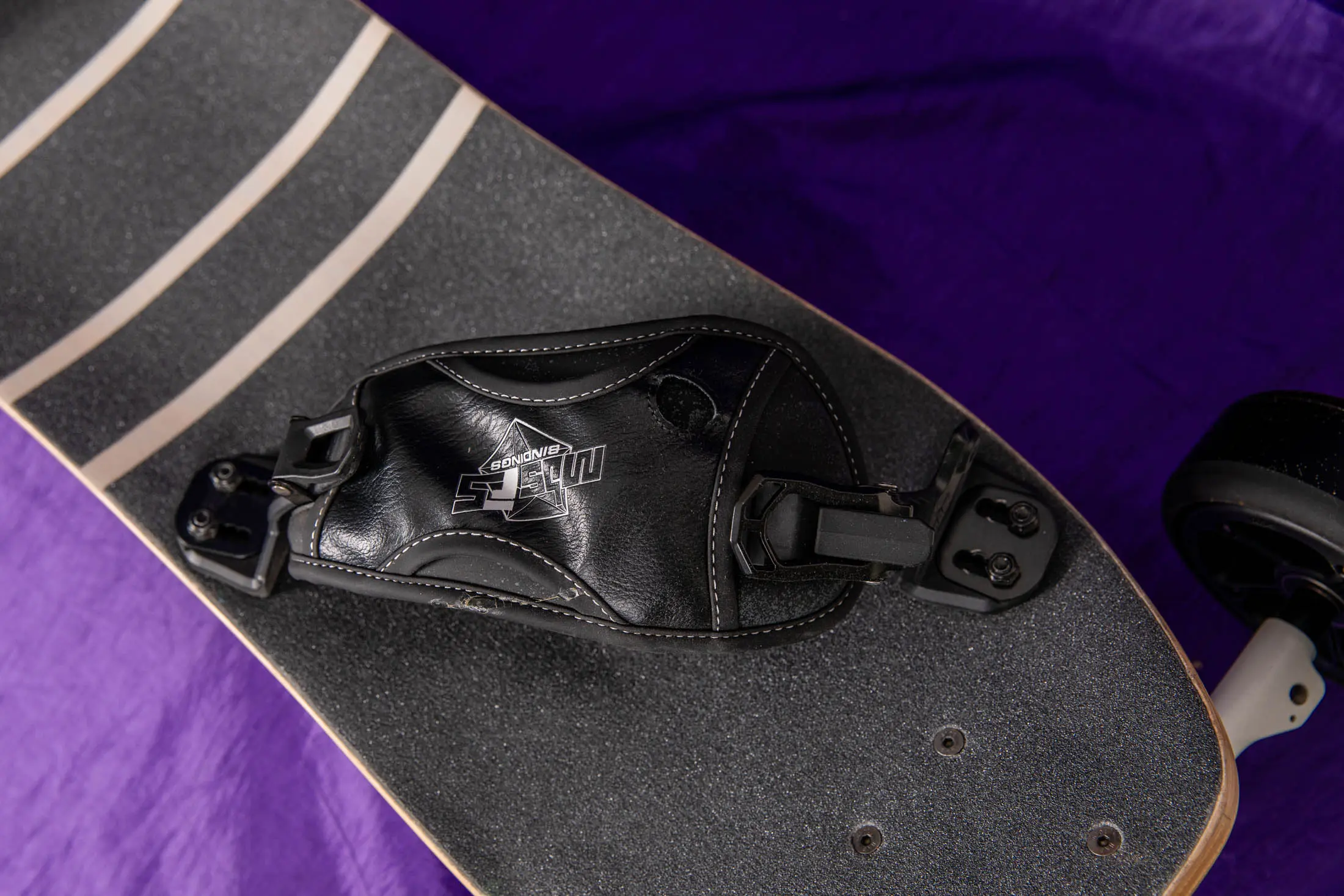 Skateboard binding on grip-tape deck.
