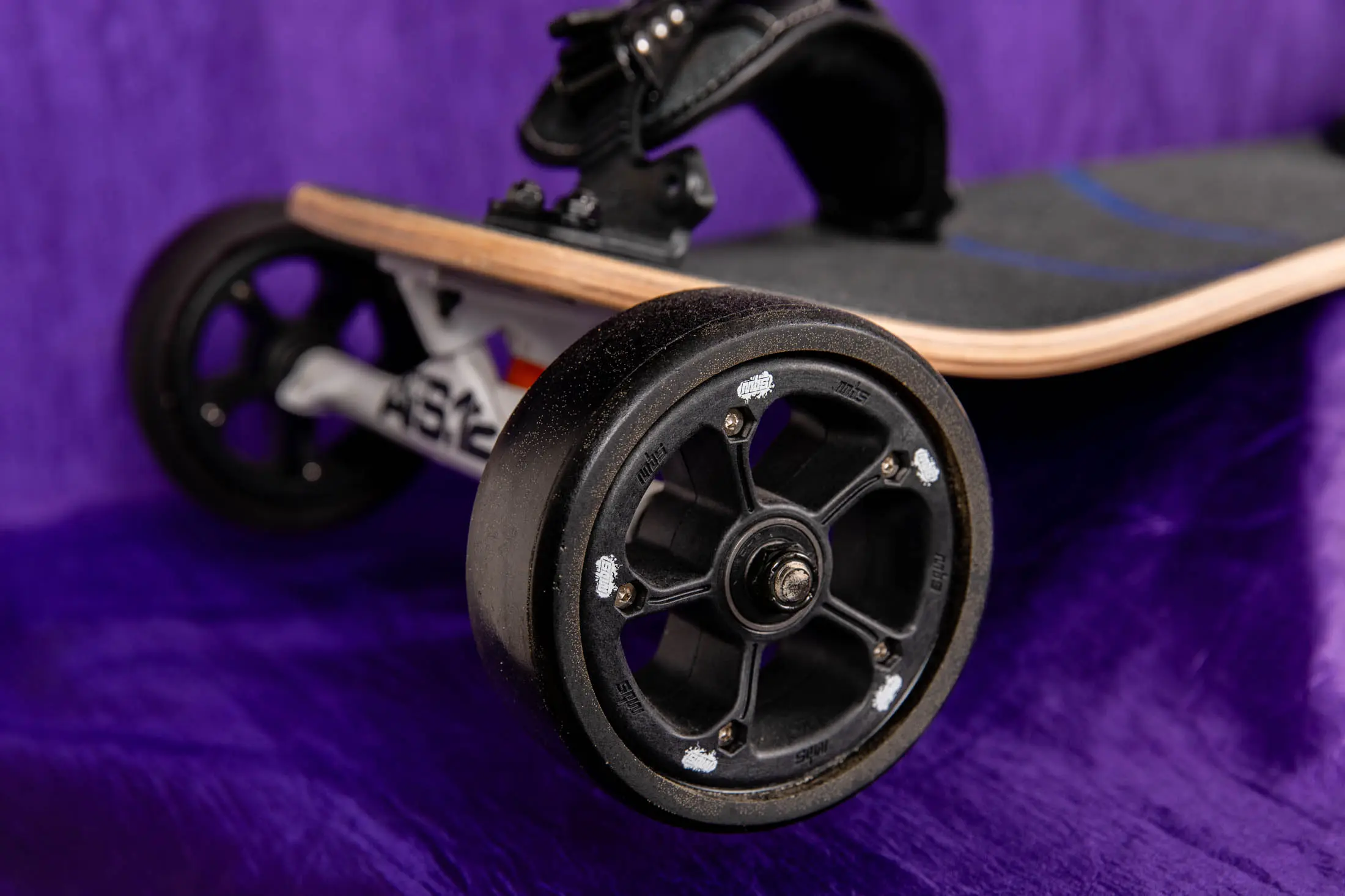 Black skateboard wheel on purple background.