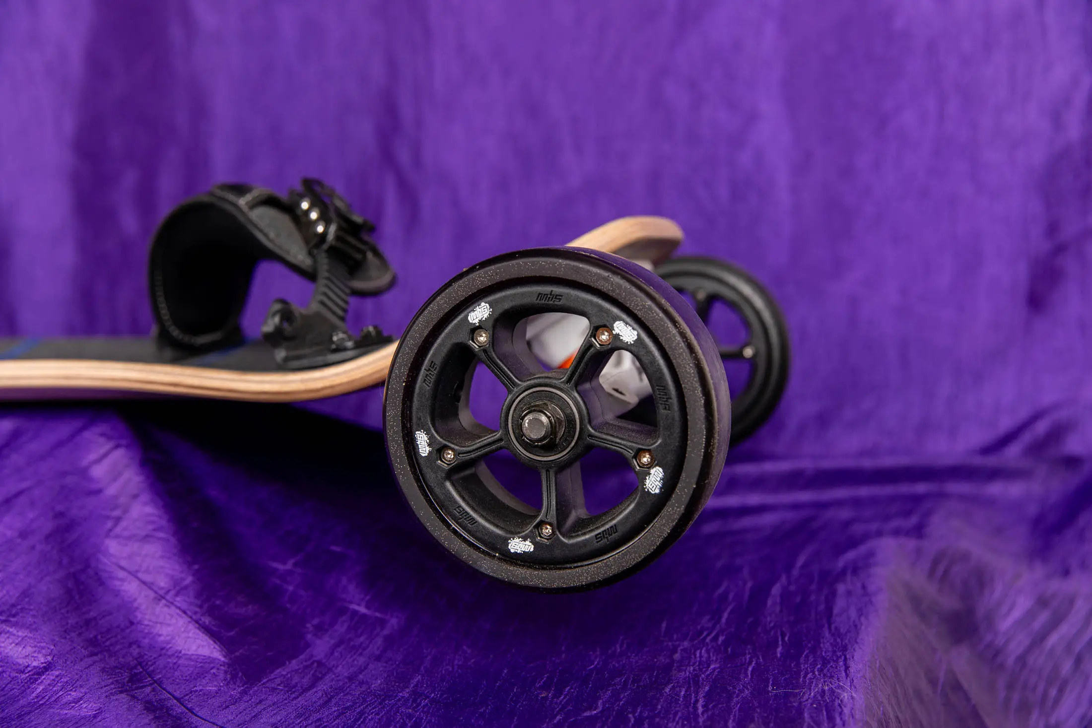 Skateboard wheels on a purple fabric background.