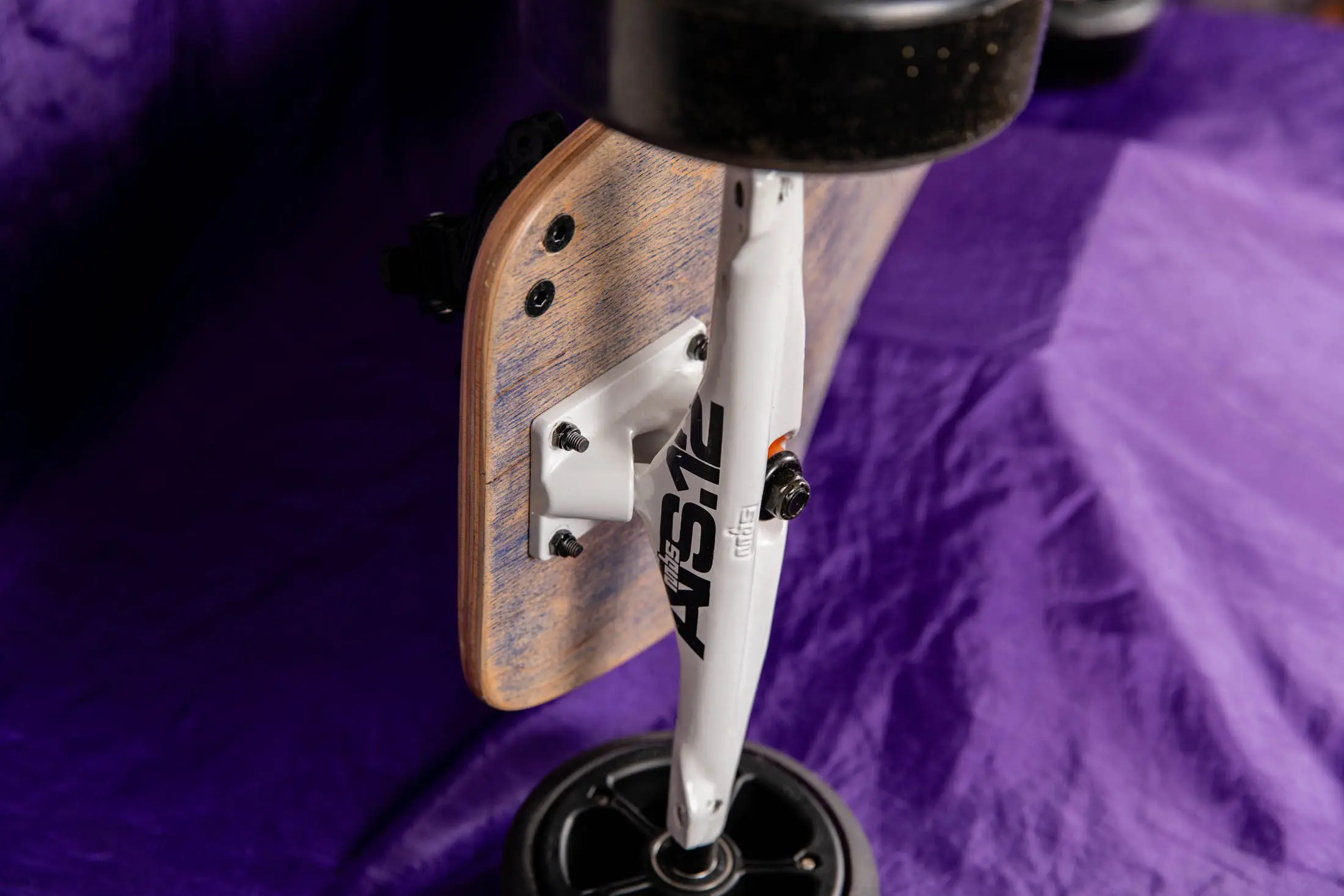 Skateboard on purple fabric background, close-up.