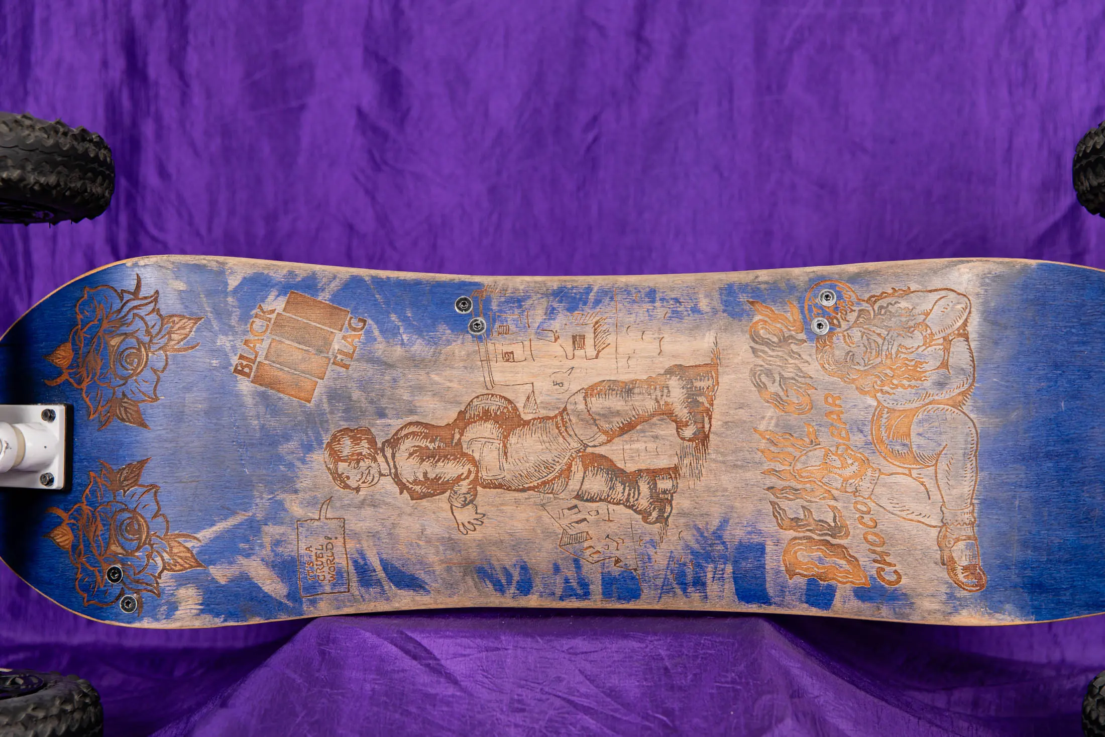 Engraved skateboard deck on purple background.
