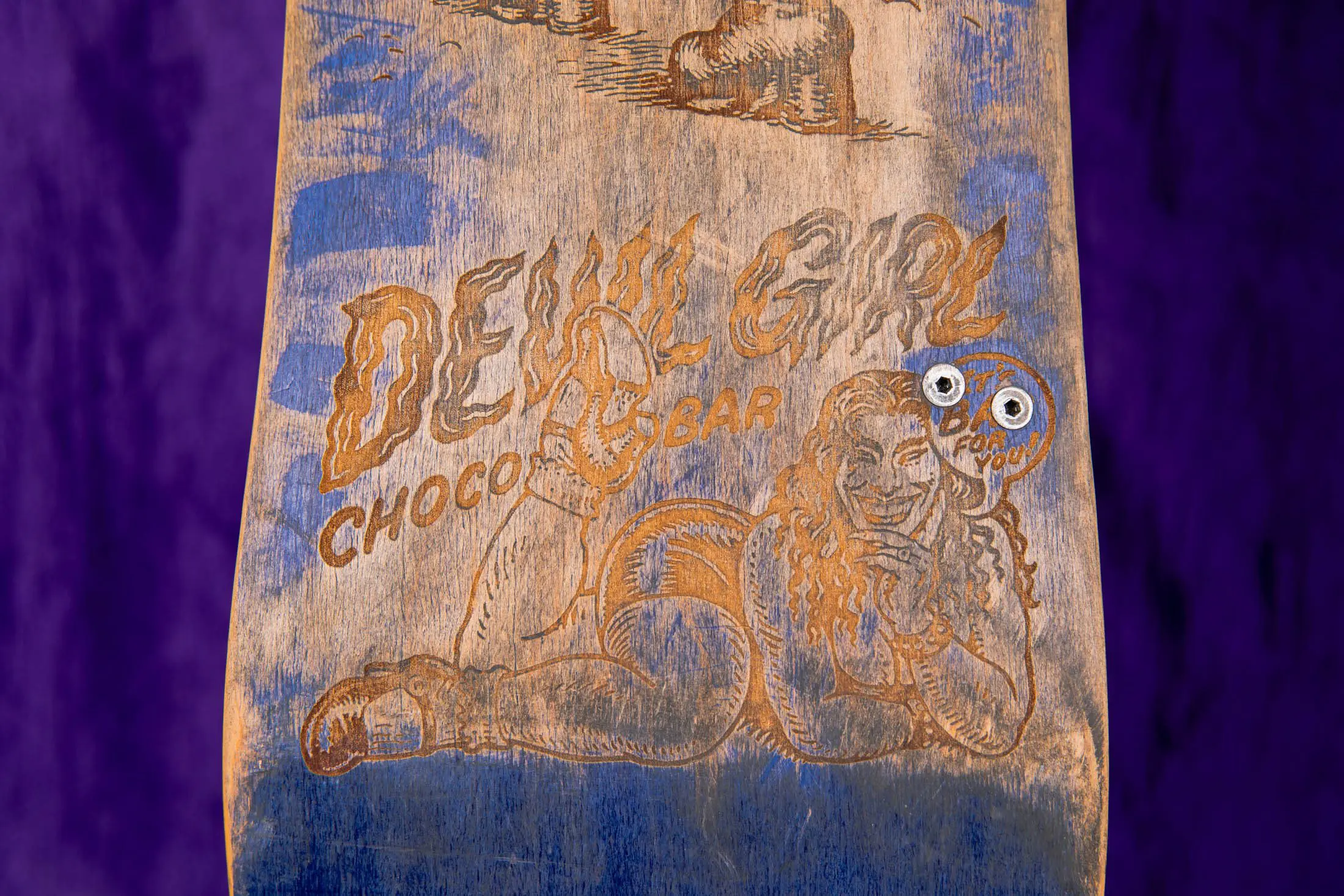 Engraved skateboard with vintage-style illustration design.