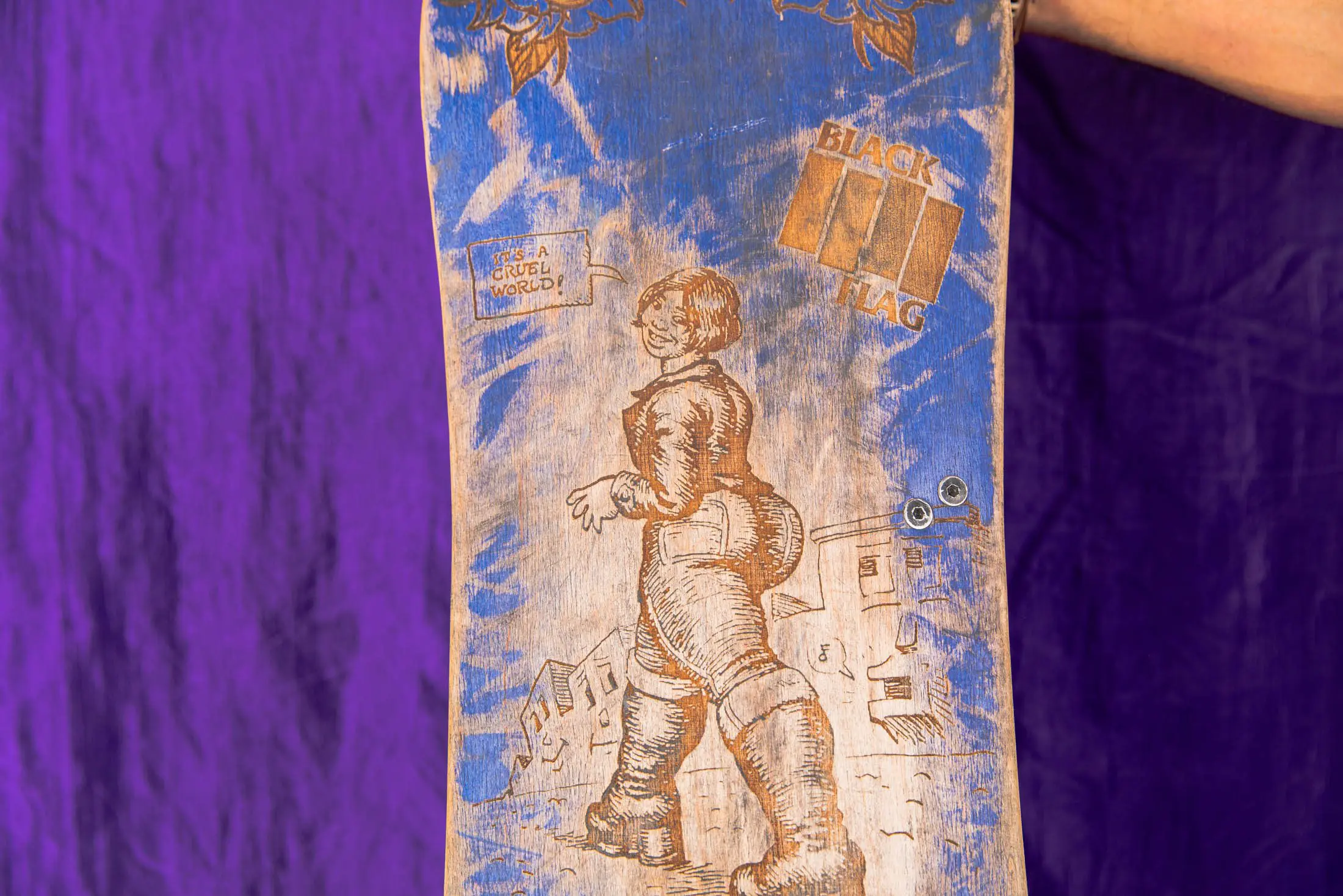 Vintage skateboard with intricate blue artwork.