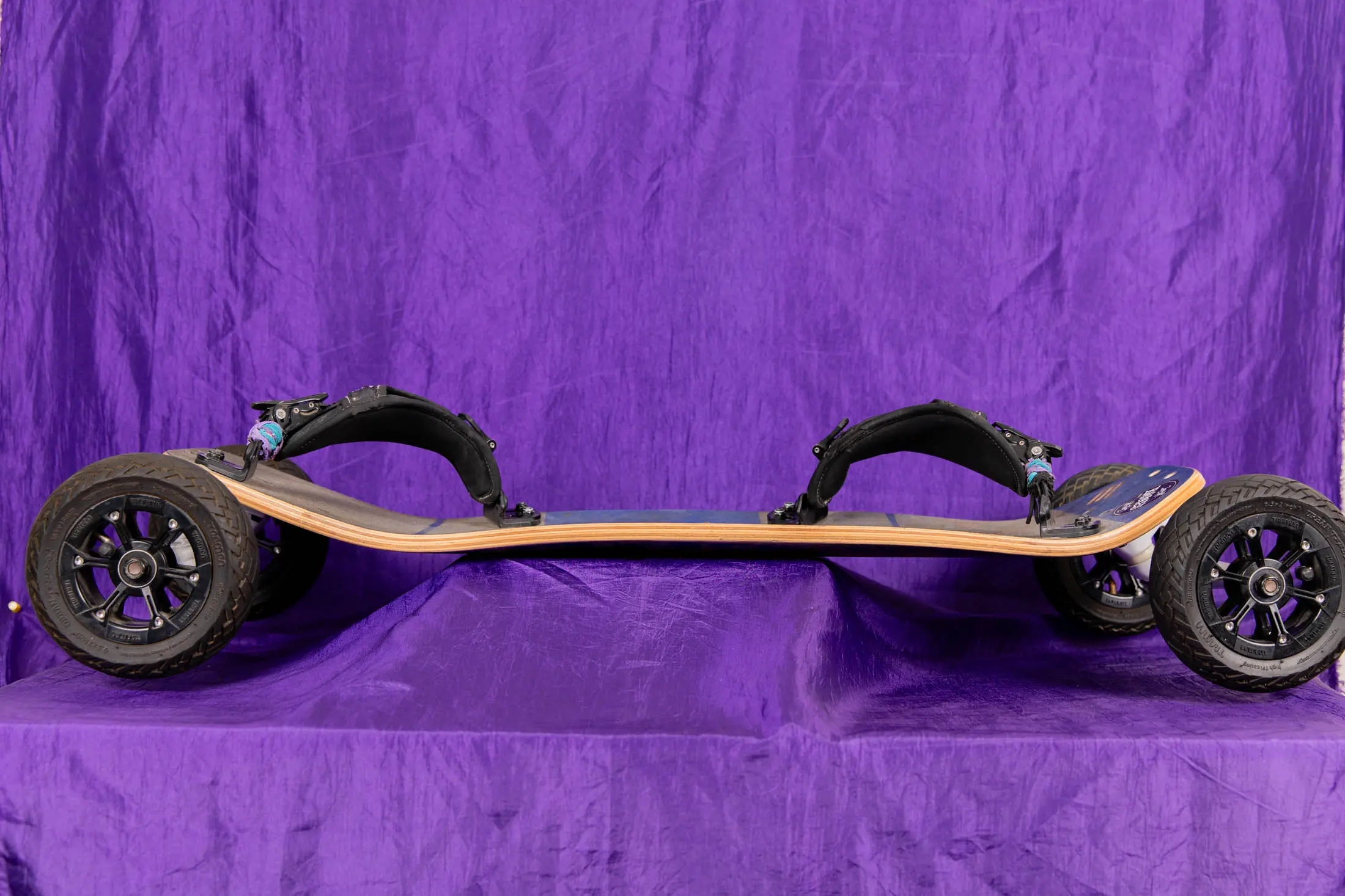 Off-road skateboard with large wheels.
