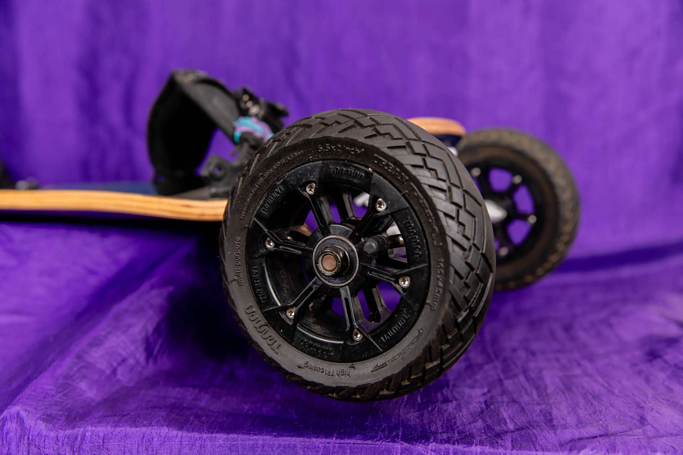 Off-road skateboard wheel on purple background.