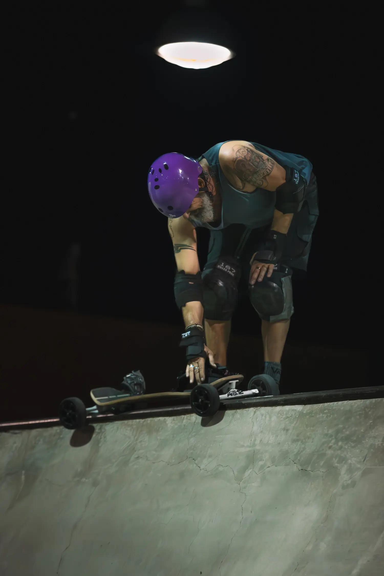 Skateboarder preparing to ride at night.